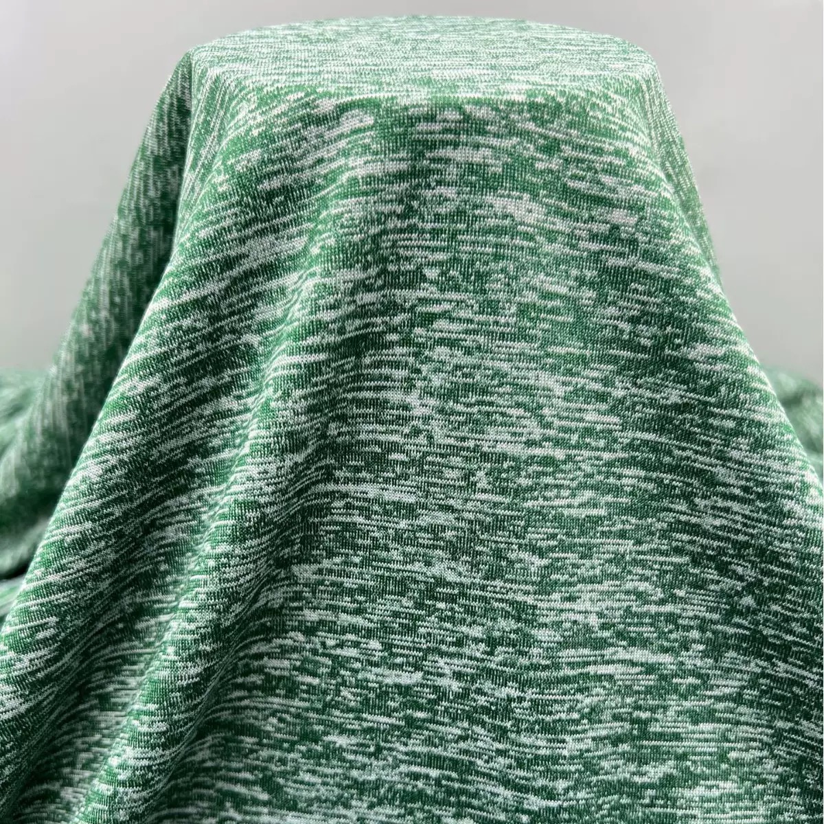 Cationic knit fabric draped under natural light showing textured color effect