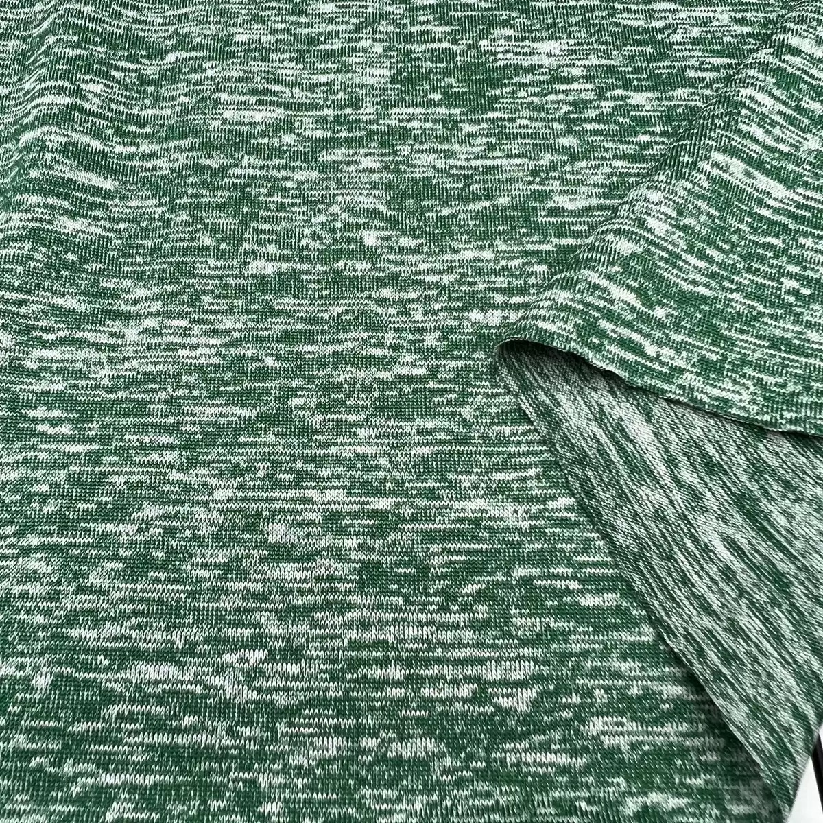 Green cationic single jersey fabric with two-tone heather texture