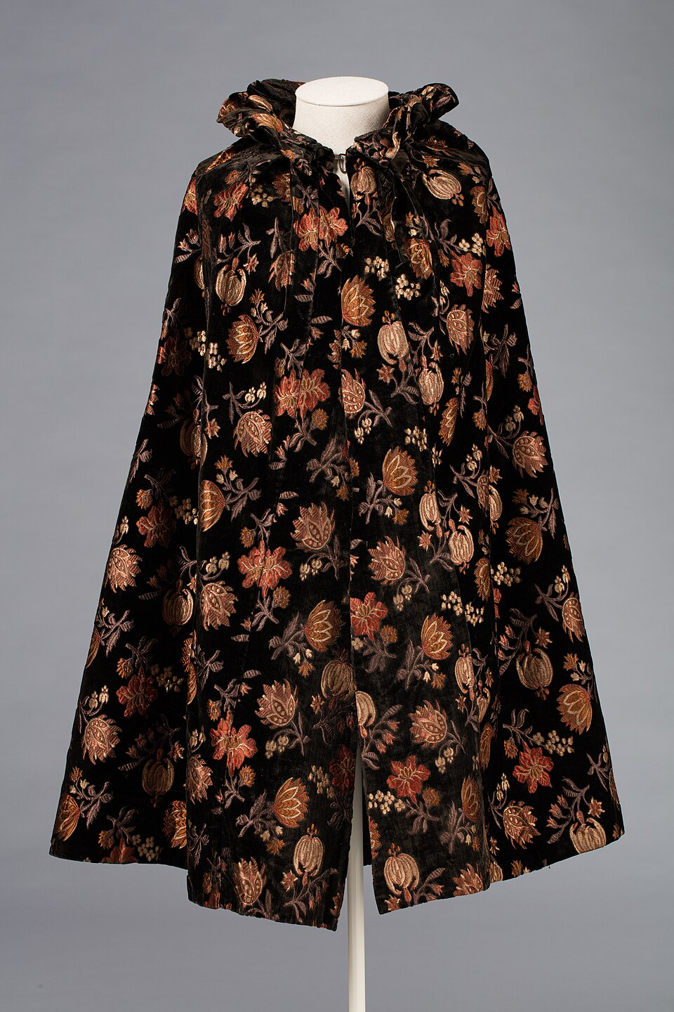 A museum cape made from figured velvet, showing that a finished item includes construction and components beyond the face fabric