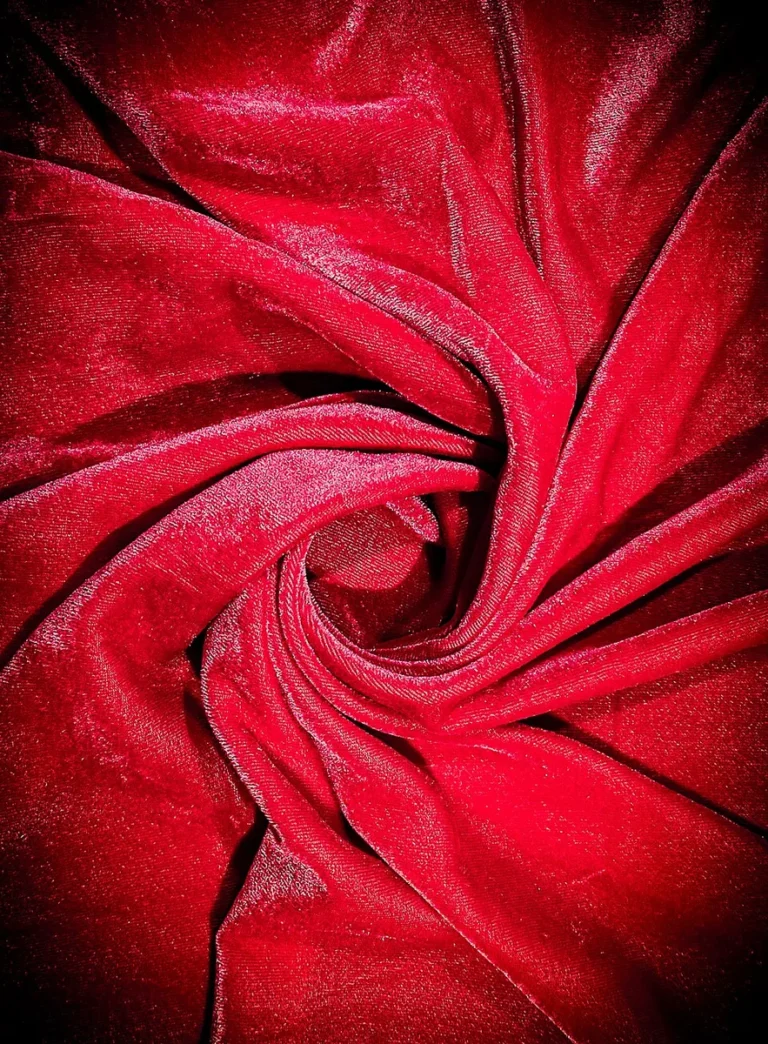 Red velvet fabric arranged to show directional pile and reflected light