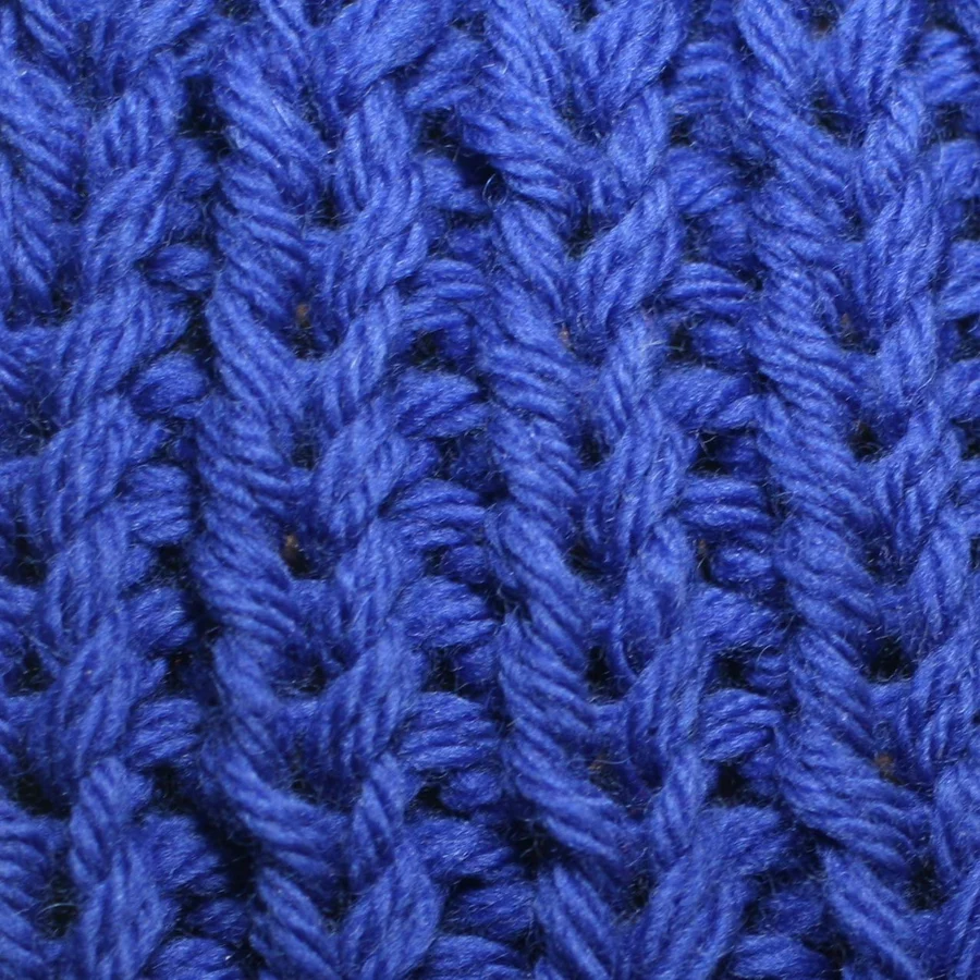Close-up photograph of blue ribbing with raised vertical knit columns and recessed channels