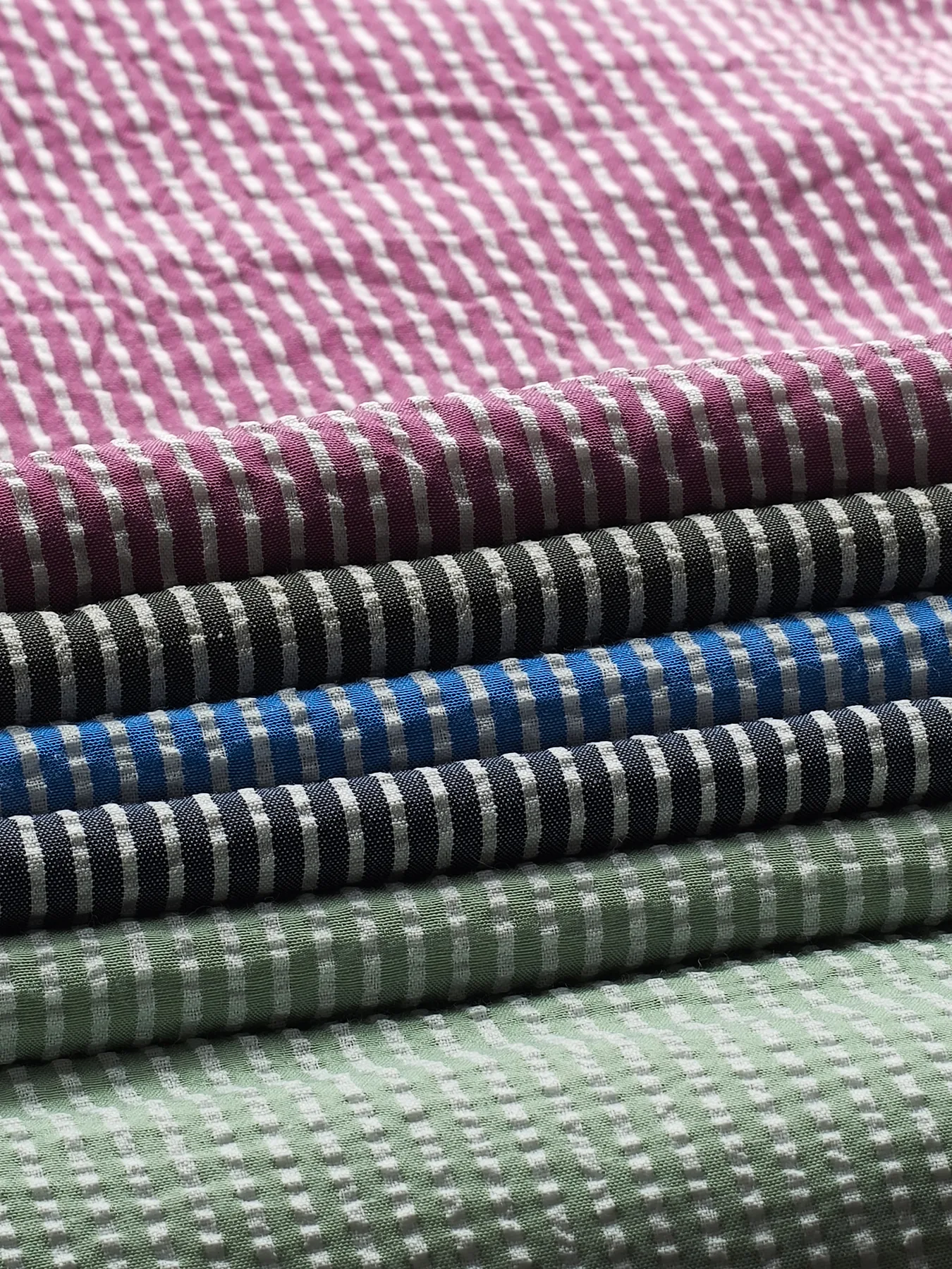 Close view of puckered stripes on folded seersucker fabrics